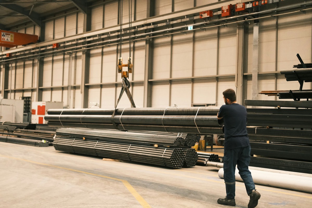 A worker walking through a steel warehouse