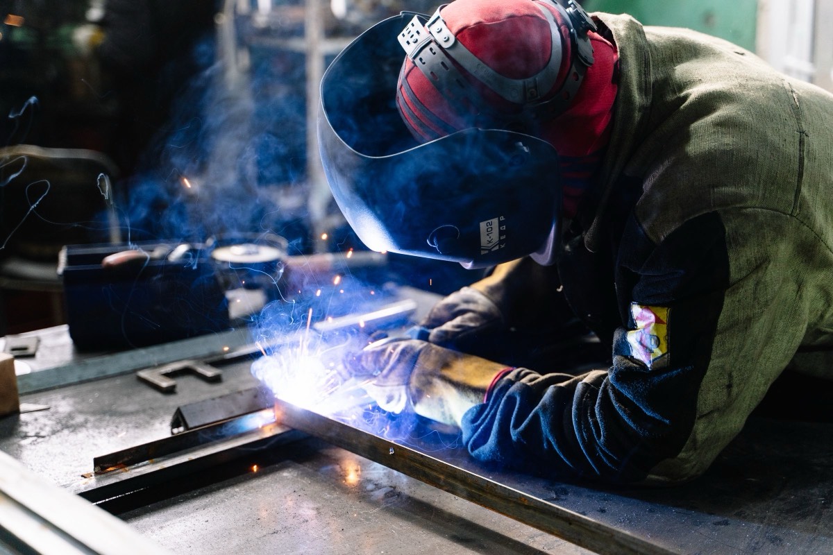 A welder at work behind a welding mask
